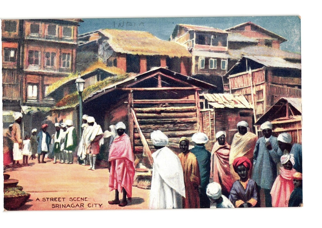 Early 20th Century Street Scene in Srinagar City, India by Raphael Tuck & Sons postcard: A vibrant street scene depicts numerous figures in traditional attire amidst buildings with wooden and mud construction. Most individuals are seen wearing various robes and head coverings, with some n