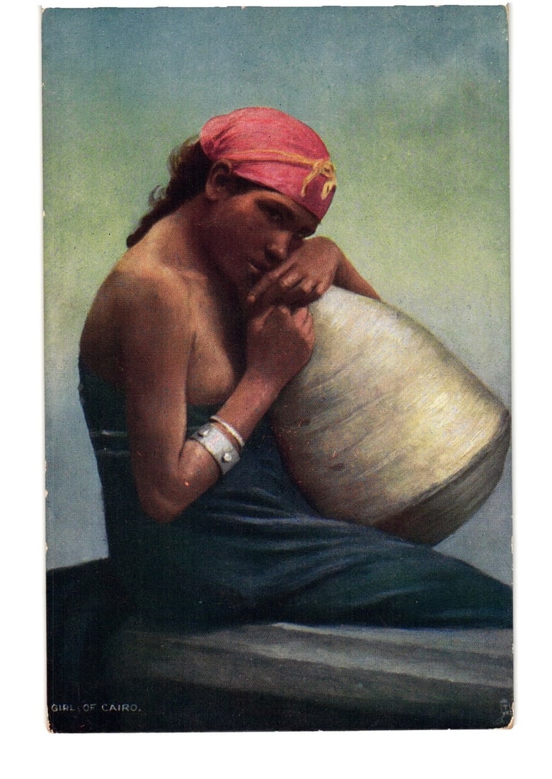 Early 20th Century Postcard Depicting a Seated Girl from Cairo Holding a Large Vessel: A chromolithograph postcard featuring a seated woman in a three-quarter portrait, positioned slightly to the left. She wears a red headscarf with a yellow patterned band and a dark blue garment, with 