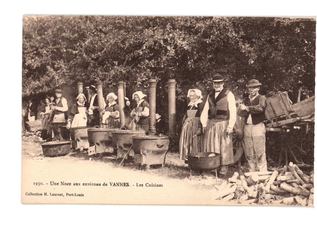 1930 Wedding Cooks Preparing Feast with Large Cauldrons, Vannes Vicinity Postcard.: A sepia-toned photograph captures an outdoor wedding feast preparation scene. Numerous individuals, some in traditional attire, are gathered around a line of large metal cauldrons over open fires. The