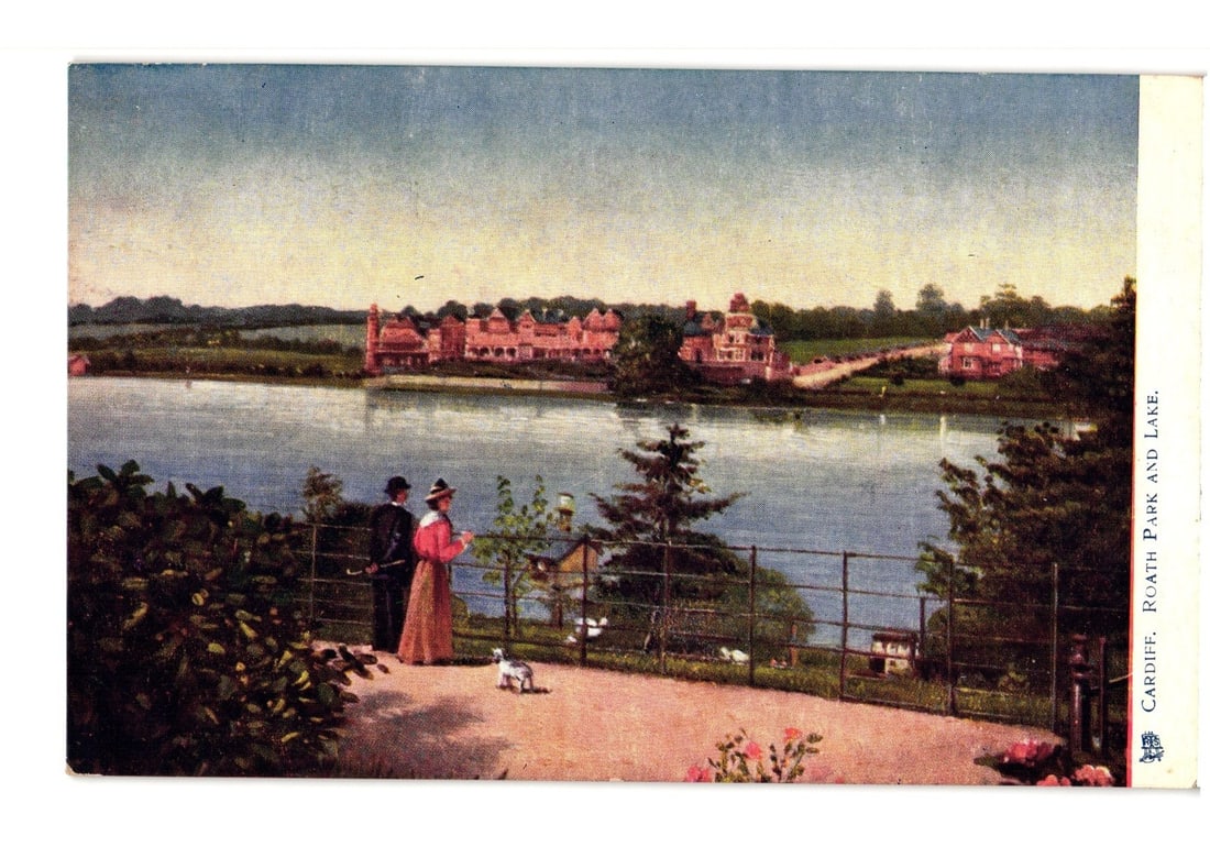 Scenic Postcard of Cardiff's Roath Park Lake, with Figures and Prominent Lakeside Building: A panoramic view of Roath Park Lake in Cardiff, featuring a grand, multi-story building complex with distinct red roofs visible across the water. Several smaller structures and mature trees are also s