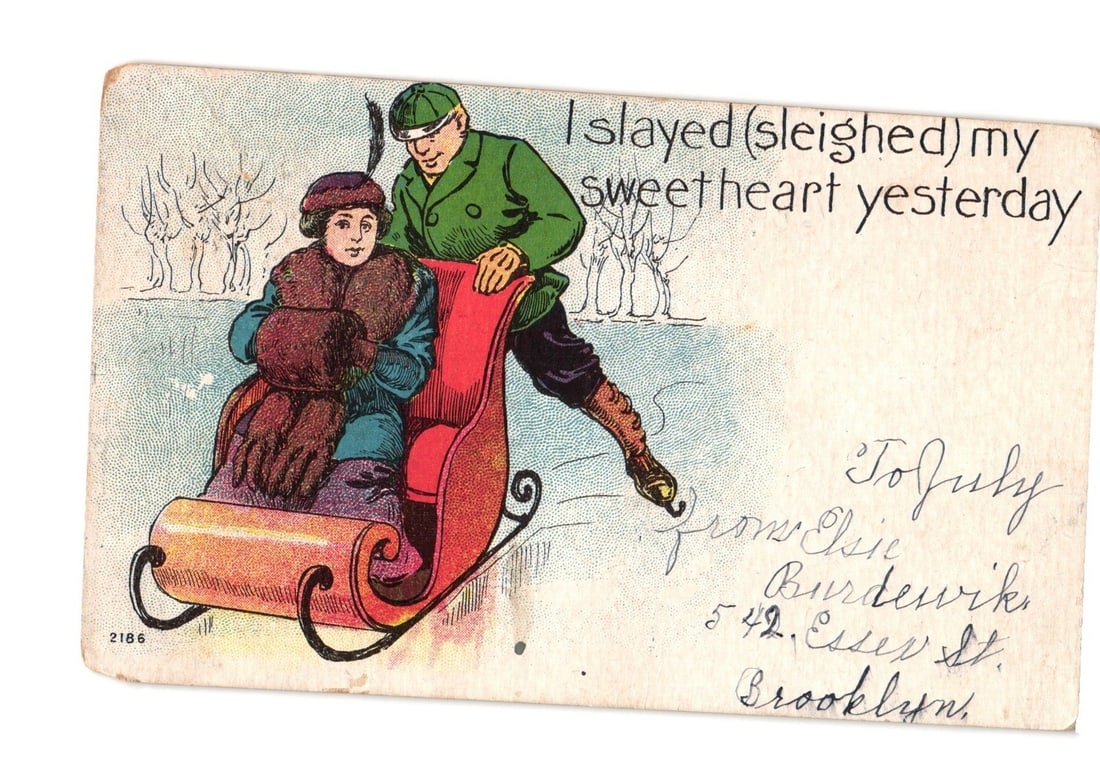 Vintage Chromolithograph Postcard: Man Pushes Woman in Sleigh, 'I Slayed My Sweetheart' Caption: Primary subject is an illustrated scene of a man pushing a woman in a sleigh through a snowy landscape. The woman is seated, wrapped in a fur-lined coat and hat, looking towards the viewer. The man st