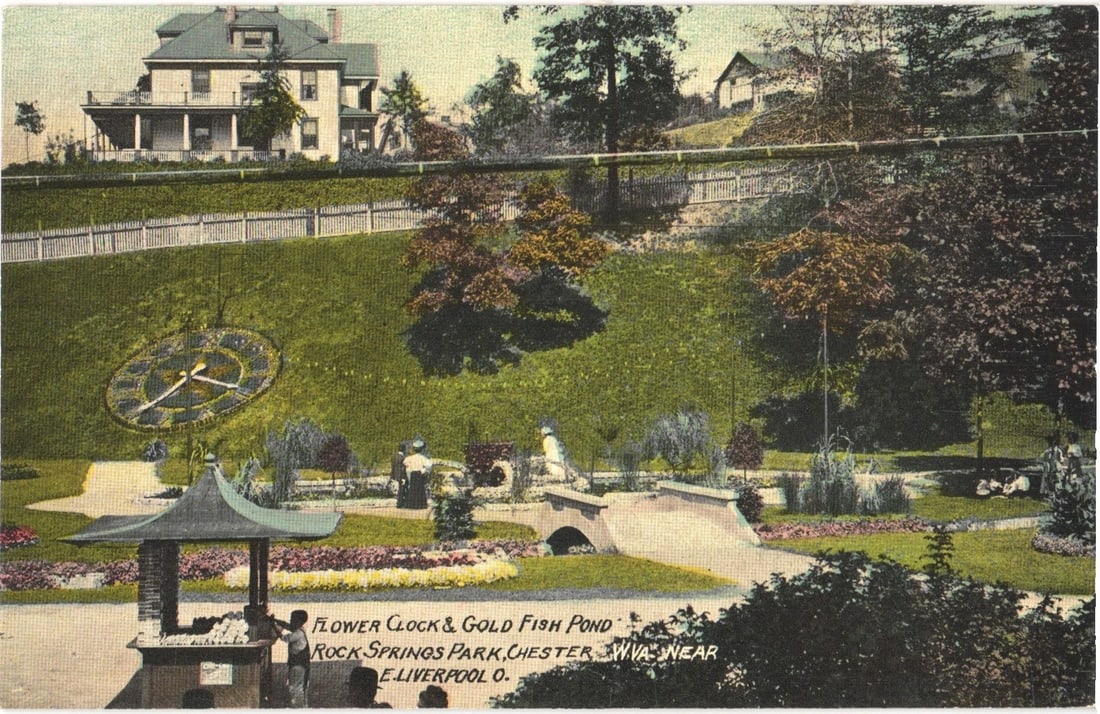 Flower Clock & Gold Fish Pond, Rock Springs Park, Chester, WV, early 20th century postcard.: A vibrant scene depicting the Flower Clock and Gold Fish Pond at Rock Springs Park. The foreground features a decorative, open-sided shelter with a peaked roof, where several individuals are gathered.