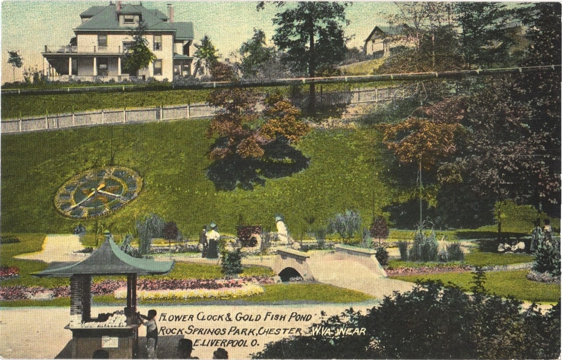 Flower Clock and Gold Fish Pond, Rock Springs Park, Chester, WV, Early 20th Century postcard.: A picturesque park scene features a large floral clock displaying Roman numerals and hands, set into a gently sloping grassy hillside on the left. Below, a goldfish pond with a small arched bridge is 