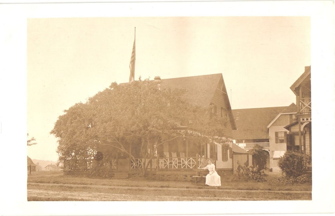 Early 20th Century Real Photo postcard of a stately house, a woman on its porch, and an American (1 of 2)