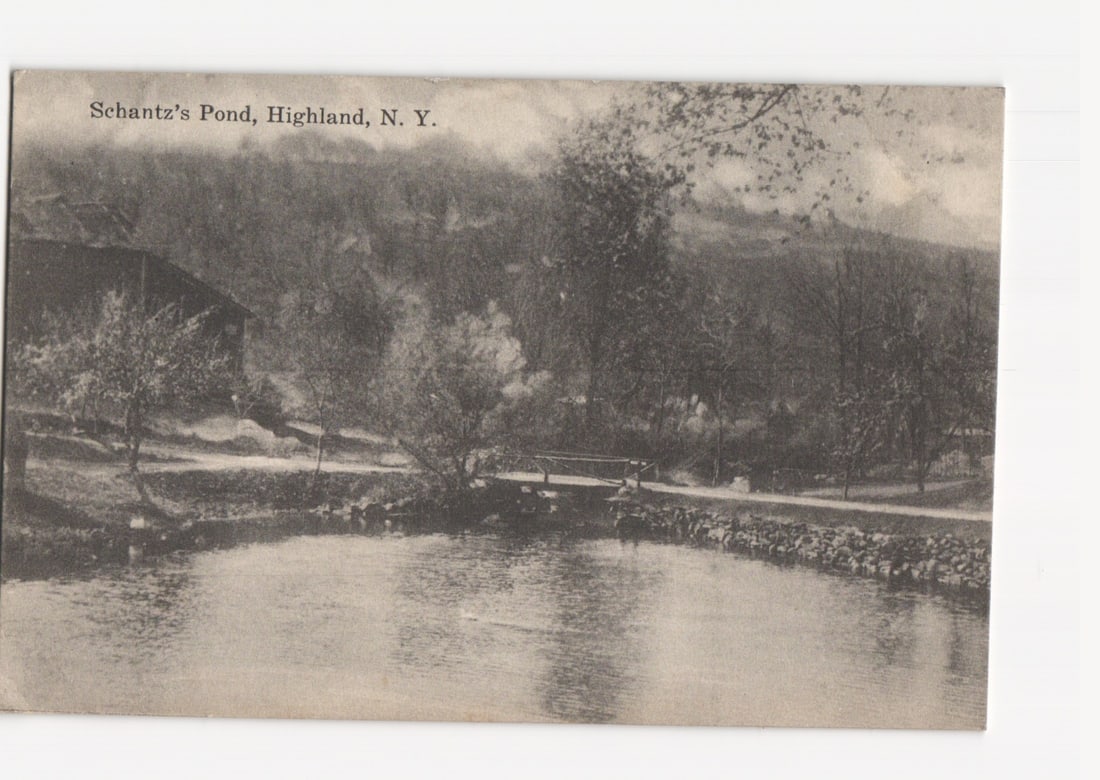 Early 20th-century landscape postcard featuring Schantz's Pond with a small bridge in Highland, New: Please review the photos carefully for additional condition details. Note that scans may appear slightly darker or lighter than the item's true appearance, and minor scanning artifacts may be visible.