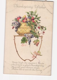 Thanksgiving Wishes chromolithograph postcard featuring fruit basket with grapes, apples, and