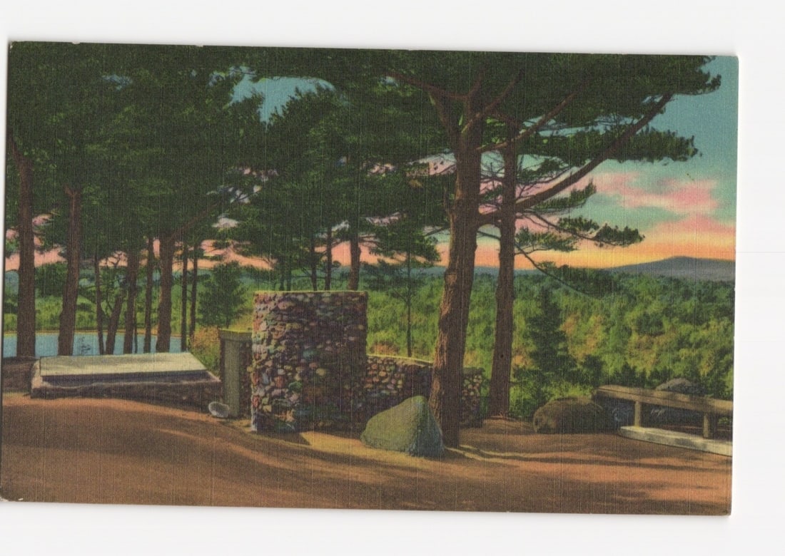 Scenic photochrome postcard featuring the Baptismal Font at Cathedral of the Pines, Rindge, New: A large, rugged stone structure, identified as the Baptismal Font, is depicted center frame. It is constructed from various sizes and colors of natural, unmortared stones. A shallow basin-like recess 