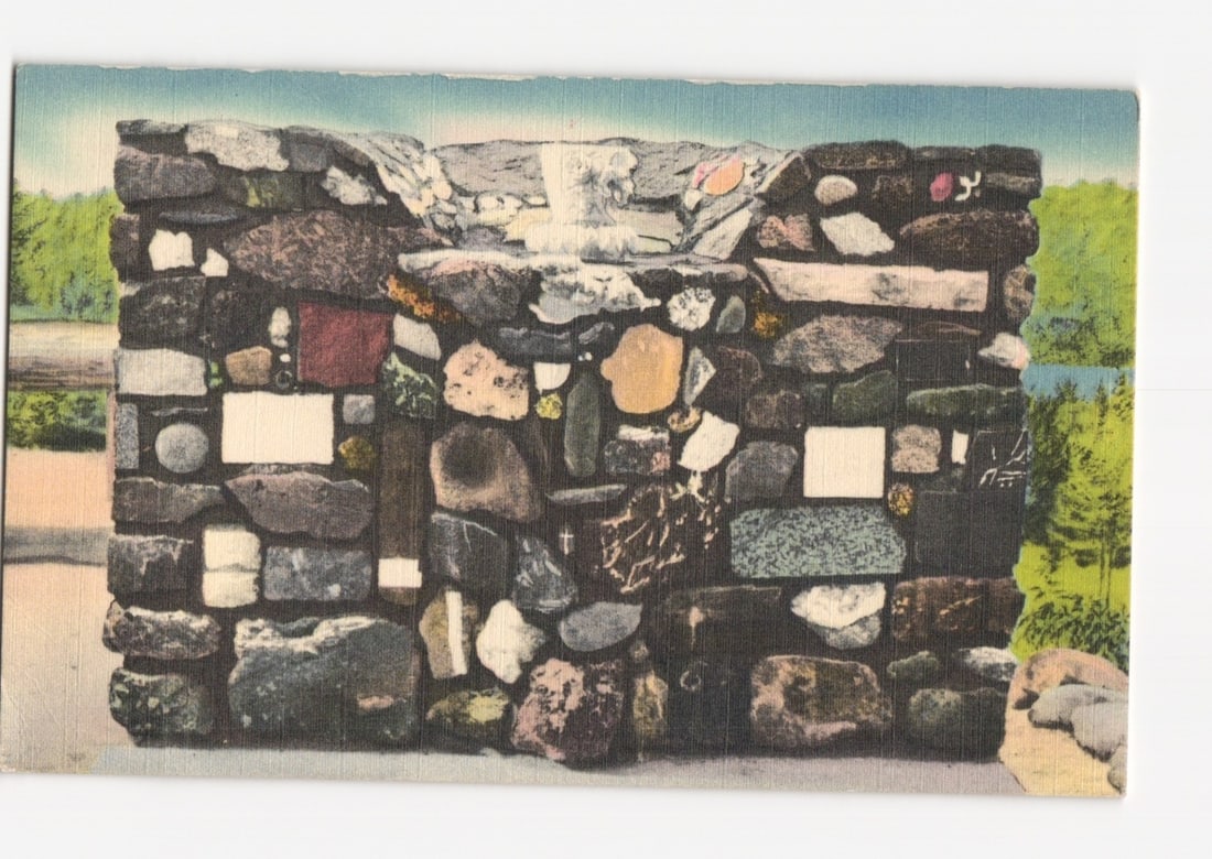 Cathedral of the Pines Outdoor Altar, Pulpit, Lectern, and Font, Forest Landscape postcard: A panoramic view of the Cathedral of the Pines, featuring an outdoor altar and associated structures amidst a forest. Tall evergreen trees frame the foreground, casting shadows. Two stone structures a