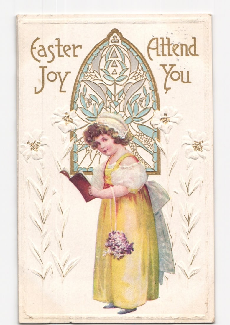 Early 20th Century Easter Joy postcard featuring a young girl, stained glass, and embossing.: A young girl in a yellow dress and white bonnet holds a red book and a small bouquet of purple flowers. She stands before an arched stained-glass window design with blue and white geometric and floral