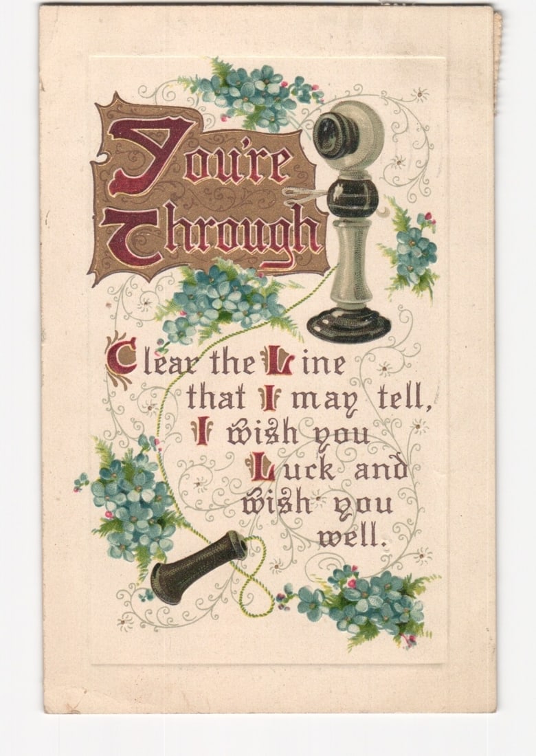 Decorative chromolithograph postcard featuring an early telephone and 'You're Through' sentiment,: An ornate illustration of an early telephone receiver on a stand, accompanied by a separate mouthpiece. The design is framed by sprays of blue forget-me-not type flowers and decorative swirling vines.
