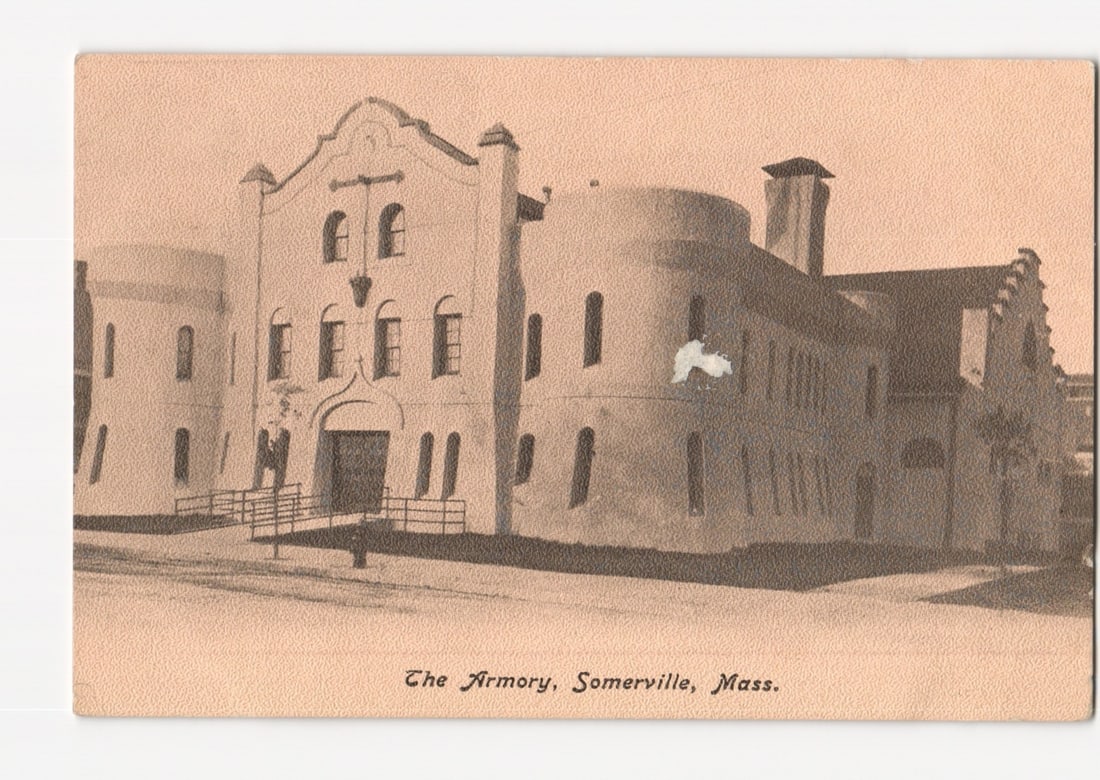 The Armory, Somerville, Massachusetts, early 20th century architectural view postcard.: A sepia-toned photographic illustration depicts The Armory building in Somerville, Massachusetts. The large, multi-story structure features a central arched entrance with railings leading to it. The f