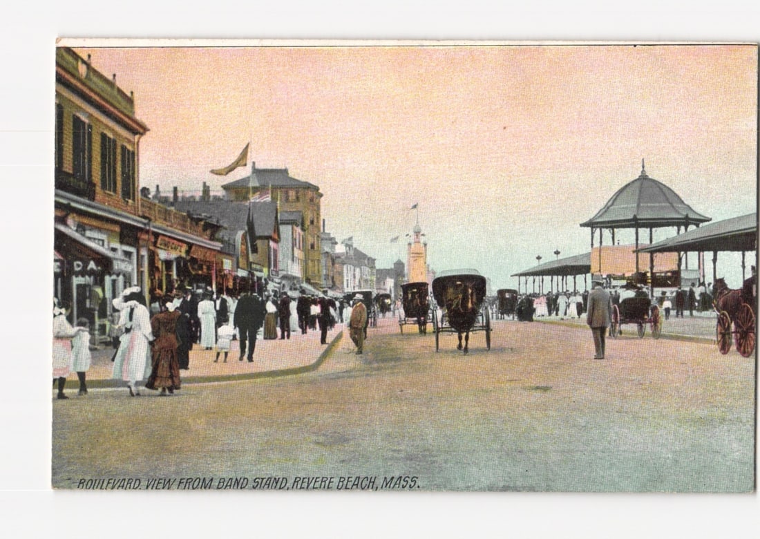 Historic Postcard: Boulevard View from Bandstand, Revere Beach, Massachusetts, Early 1900s: A busy street scene depicts a wide boulevard lined with buildings on the left and a large domed pavilion on the right. Numerous pedestrians in early 20th-century attire stroll along the pavement. Seve