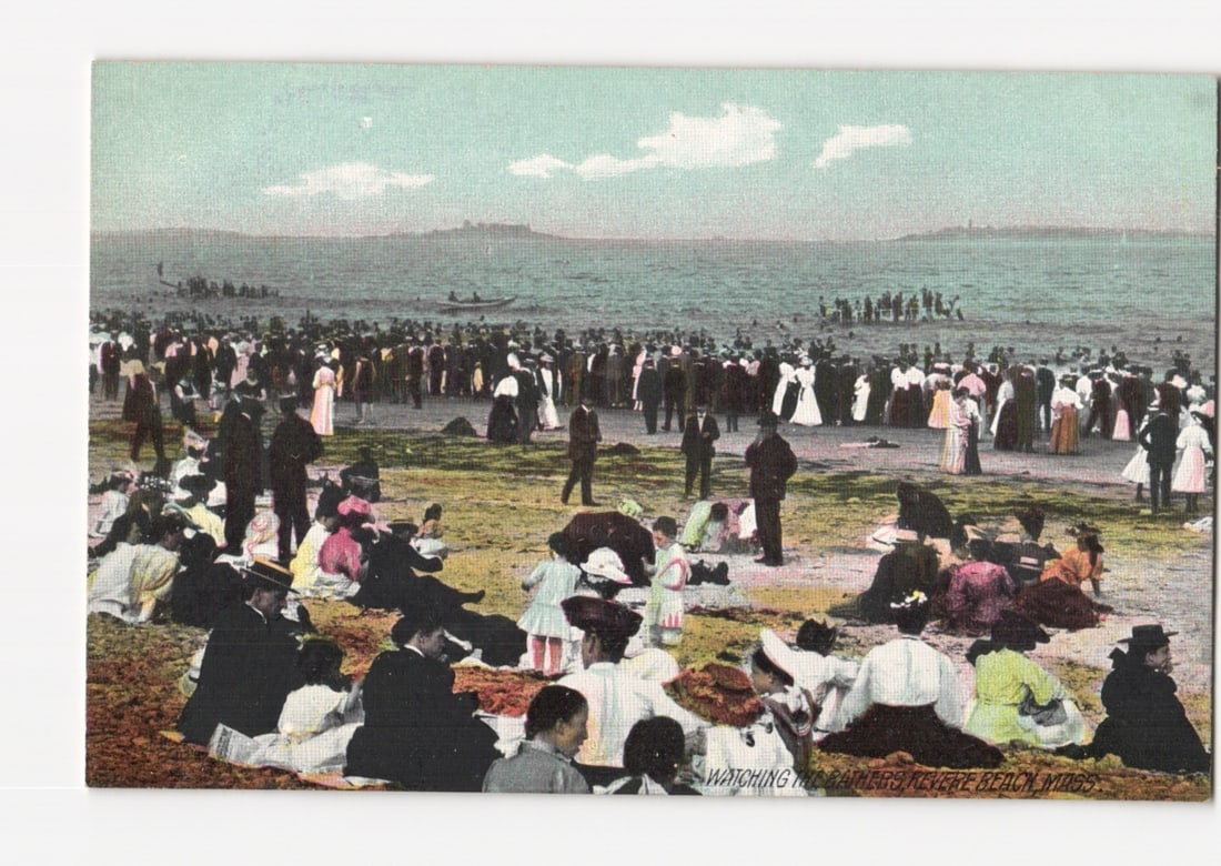 Revere Beach, Massachusetts, postcard: A large crowd watching swimmers, early 20th-century scene.: A large crowd of men, women, and children gathers on the sandy and grassy areas of Revere Beach, Massachusetts. Many individuals stand close to the water's edge, while others are seated further back. 