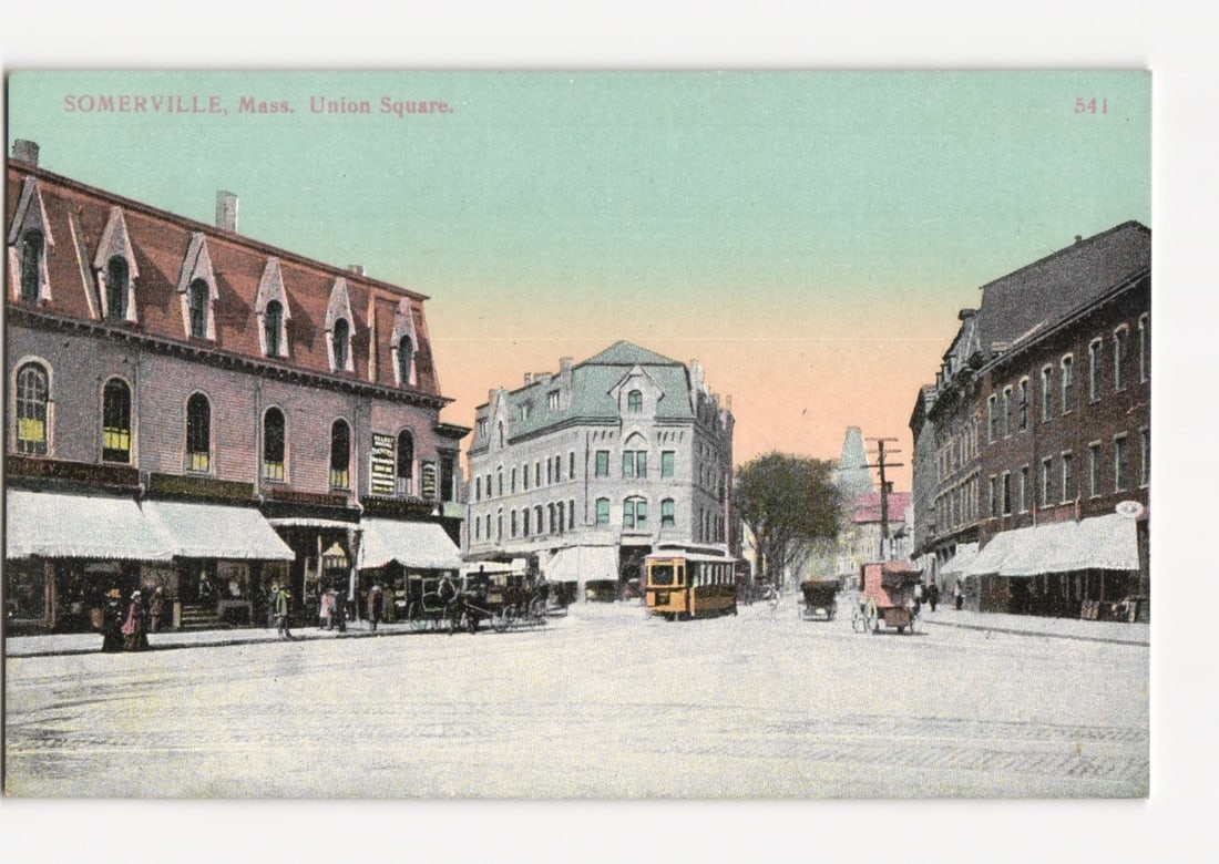 Somerville, Mass. Union Square, bustling street scene with tram and horse-drawn carriages postcard: A wide-angle, colored lithograph postcard depicts a bustling street scene at Union Square, Somerville, Mass. Three prominent multi-story buildings frame the square: a large brick building with a mansa