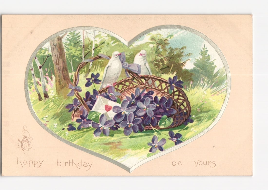 Early 20th-century illustrated postcard with white doves, basket, and flowers in a heart vignette.: A chromolithographic illustration depicts two white doves next to a woven basket filled with purple flowers. A small white envelope with a red heart seal rests within the flowers. The scene is framed 