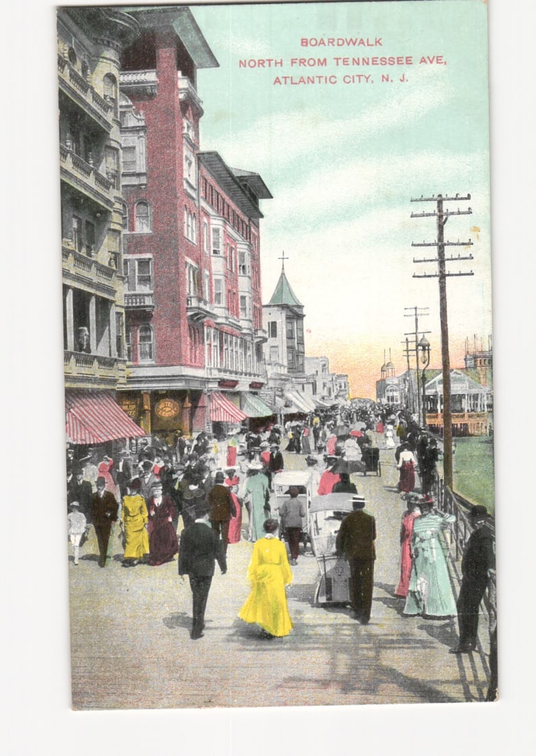Busy Boardwalk Scene, North from Tennessee Ave, Atlantic City, N.J. c.1909 postcard: A bustling street scene on the Boardwalk, looking north from Tennessee Avenue in Atlantic City, New Jersey. Numerous pedestrians in early 20th-century attire fill the boardwalk. Multi-story buildings 