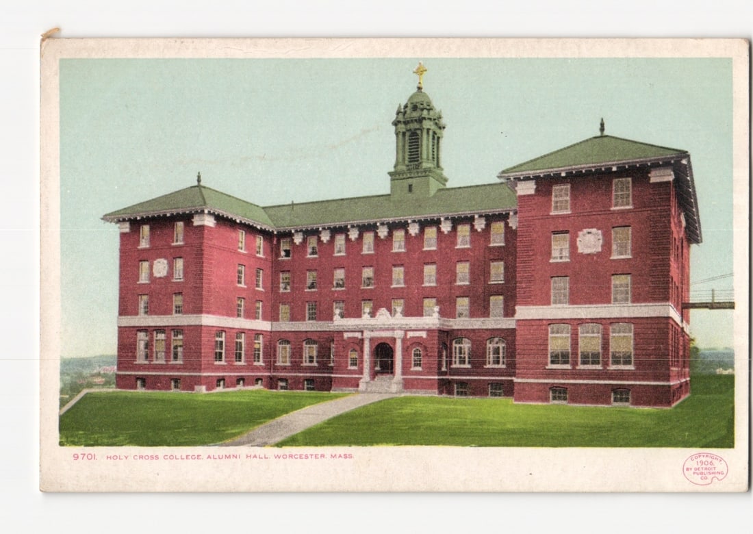 Holy Cross College, Alumni Hall, Worcester, Massachusetts, Early 20th Century Lithograph Postcard: A large, multi-story red brick building, identified as Alumni Hall of Holy Cross College, is depicted from a slightly elevated frontal perspective. The building features several wings, dark green slop