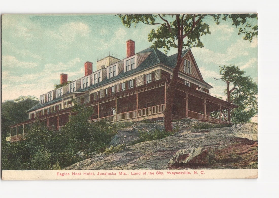 Eagles Nest Hotel, Junaluska Mountains, Waynesville, NC, circa 1913 lithograph postcard.: A large, multi-story hotel building, the Eagles Nest Hotel, is depicted prominently on a rocky, tree-covered hillside. The hotel features a wide wrap-around porch with a white railing, numerous window
