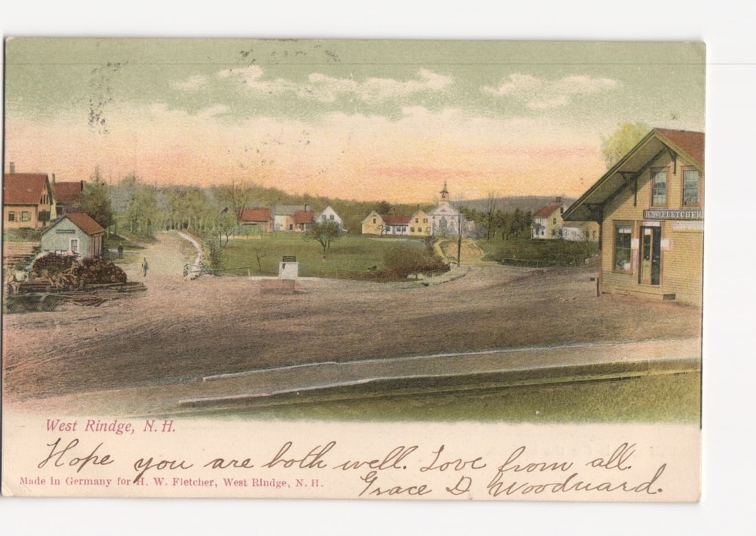 Scenic Chromolithograph Postcard of West Rindge, N.H. Village Main Street, Early 20th Century: A panoramic chromolithograph depicts a rural village scene in West Rindge, N.H. The composition features a wide unpaved road in the foreground, leading towards a cluster of residential and commercial 