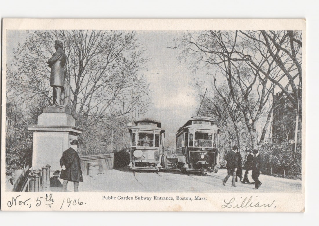 Early 20th Century Streetcars at Public Garden Subway Entrance, Boston, Massachusetts postcard: A photographic print depicting the Public Garden Subway Entrance in Boston, Massachusetts. Two early electric streetcars are positioned prominently in the center of the image. To the left, a statue of