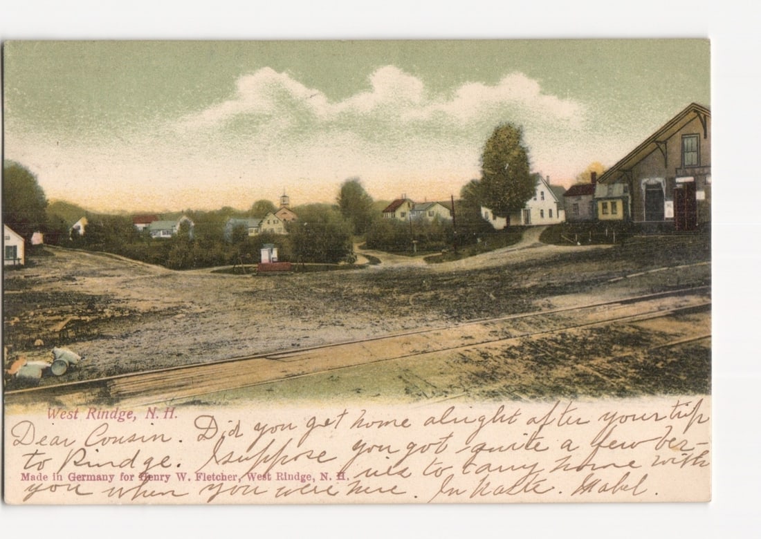 Chromolithograph postcard: Historic village scene with roads and buildings in West Rindge, NH, 1906.: A village landscape featuring converging dirt roads, scattered houses, and distant hills under a cloudy sky. A large gabled barn-like structure is visible on the right, balanced by several smaller dwe