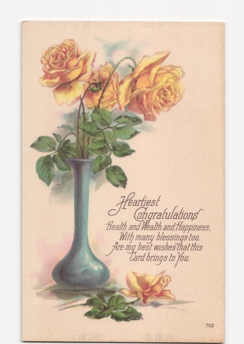 Colorful Yellow Roses in Elegant Vase: 'Heartiest Congratulations' Floral Greeting Postcard: An artistic chromolithograph depicts three vibrant yellow-orange roses arranged in a tall, slender blue-green vase. One additional rose, fully open, rests on the ground near the base of the vase, alon