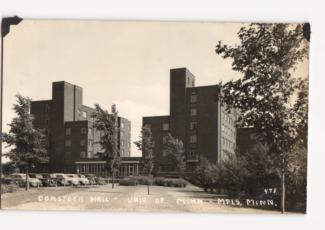 Comstock Hall, University of Minnesota, Minneapolis, mid-20th Century Real Photo postcard: Comstock Hall, a large multi-story brick dormitory complex, is prominently featured. Numerous automobiles, characteristic of the mid-20th century, are parked in a paved area in front of the building. 