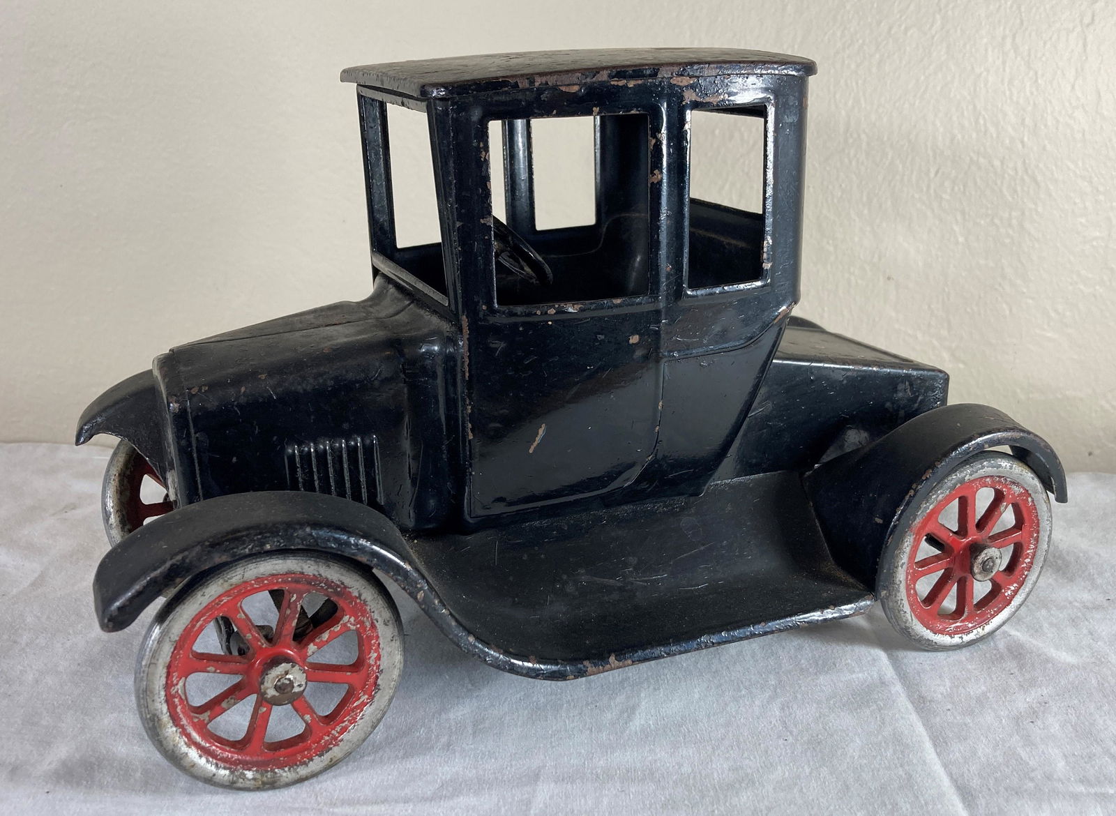 Buddy L Fliver Model T Ford Tin Lizzie Pressed Steel Toy Car: This is a wonderful toy in good condition. It shows wear consistent with age. Some dust present from display. Appears to have original finish. Metal tires. Approximately 12 inches long.