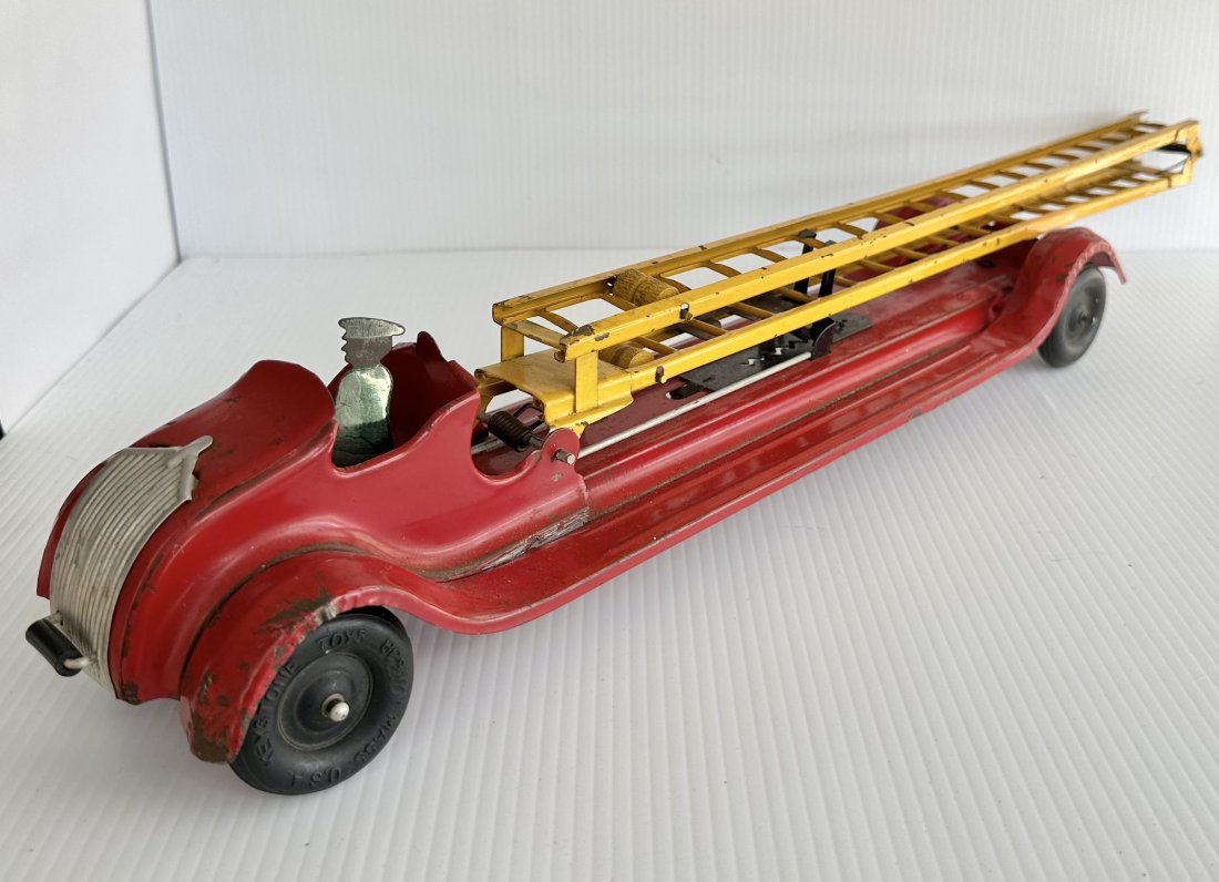 1930s Pressed Steel Keystone Bumper Activated Ladder Firetruck: This is a 1930s Pressed Steel Keystone Bumper Activated Ladder Firetruck. It is in very good working condition and measures 24 Inches long.Ladder extends to considerable height.