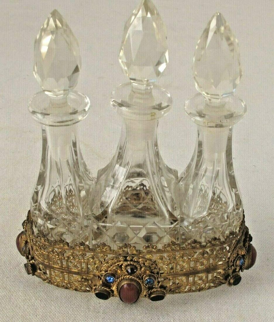 Vintage Crystal Essence Flasks Set Jeweled Holder: Stunning antique crystal perfume bottle set. The set includes three beautiful crystal perfume bottles that come in a jeweled brass holder. The brass holder is embellished with jewels on all four sides