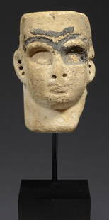 Fine Mesopotamian Frit Face Inlay: Circa Middle to Late Elamite Period circa 1500-1100 BC. A tan frit composition head, as a relief attachment, holes drilled at ears. The surface with mineral deposits and areas recessed for additional