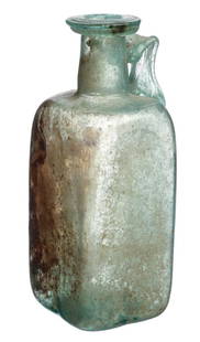 Ancient Roman Green Glass Handled Bottle: Eastern Mediterranean, ca 1st to 3rd Century AD.Blown light blue-green glass juglet having a four panel body, cylindrical neck with a flat tooled lip and an applied ribbon type handle. Overall