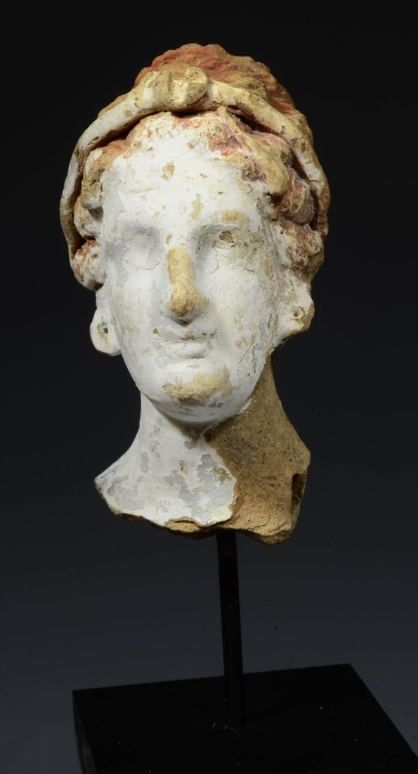 Pretty Canosan Style Terracotta Head of a Goddess: possibly Greek, Ca. 4th century BC, from Magna Grecia. Lovely female head with fine facial features and wavy hair drawn back, in a diadem. Remains of original red and white pigment. Size: 4-1/2 inches