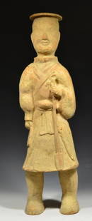 Large Han Dynasty Pottery Shaman Figure: Chineseâ€“Han Dynasty, 206 BCE-206 AD. A hollow molded pottery figure wearing a disc-type headdress and knee-length-robe tied around his waist. Holding a ceremonial staff in his left hand.