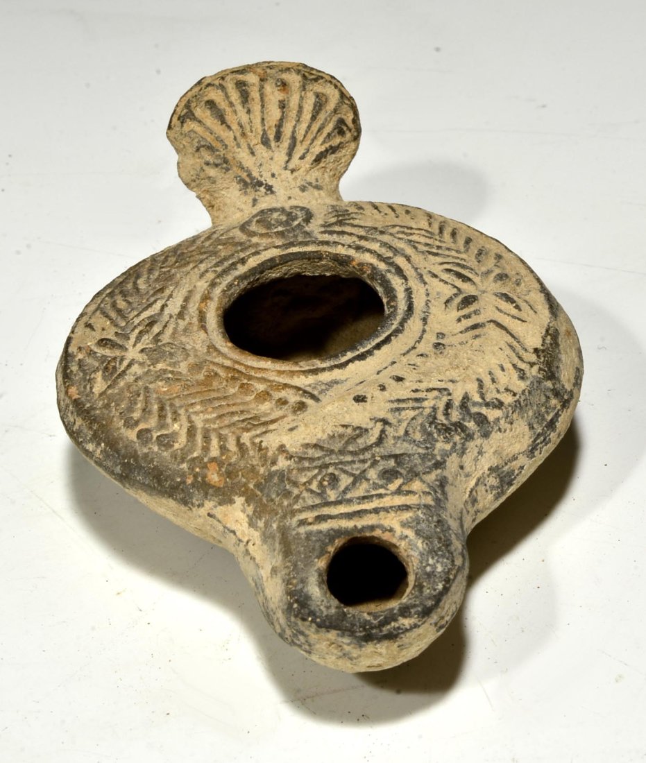 Ancient Roman Terracotta Oil Lamp: Roman ca. 63 BCE - 330 AD. Oil lamp with handle and design of leaves and geometric forms on top. M-244. Dimensions: 4" x 2-1/2"Provenance: E. Baraket, F. 2006 acquired by Dr. Henry Cherrick, a profess