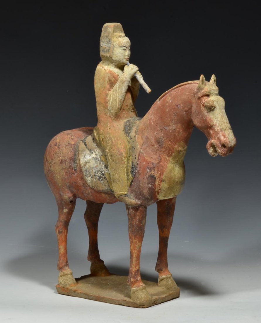 Han Dynasty Pottery Horse with Musician: Chinese Han Dynasty ca. 206 BCE - 220 AD. Pottery model of a horse with a musician rider playing the flute; the red horse standing four-square on base. Size: 13 1/8" H. Provenance: I M Chait Gallery, 