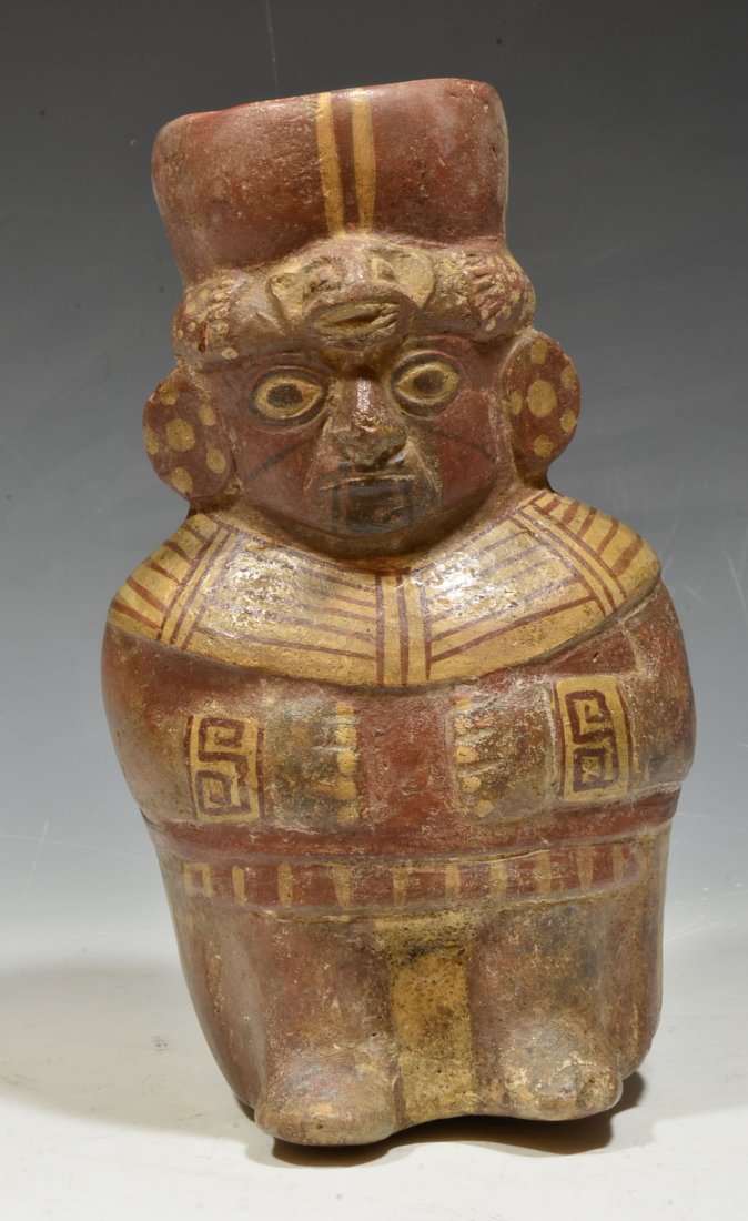 Pre Columbian Moche Pottery Nobleman Vessel: Central Coast, Ca. 400 to 600 A.D. A beautiful pottery offering vessel depicting a seated nobleman with fine stature. Handsomely molded with hands close to body and painted facial tattoos, ear ornamen