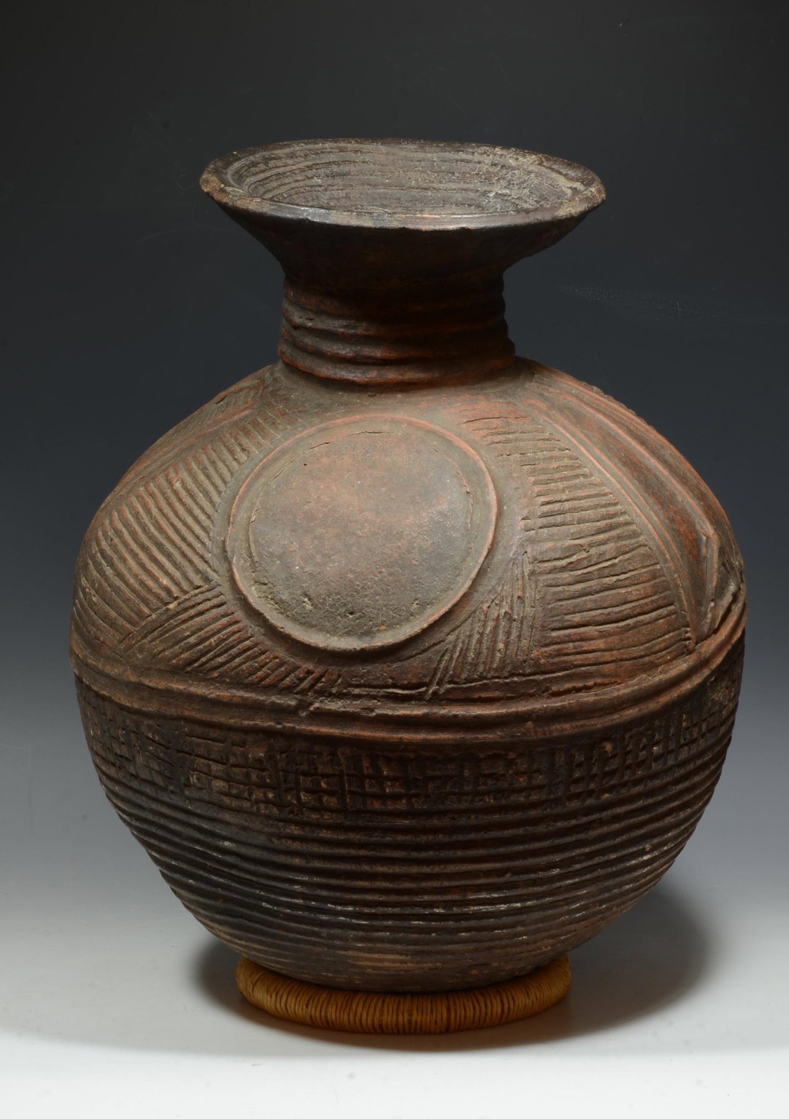 African Nupe Pottery Incised Jar: Nigeria, Early to mid 20th Century AD. A large well made dynamic water or wine jar with bulbous body, rounded base, beautifully incised and textured geometric patterns and anthropomorphic figures; a s