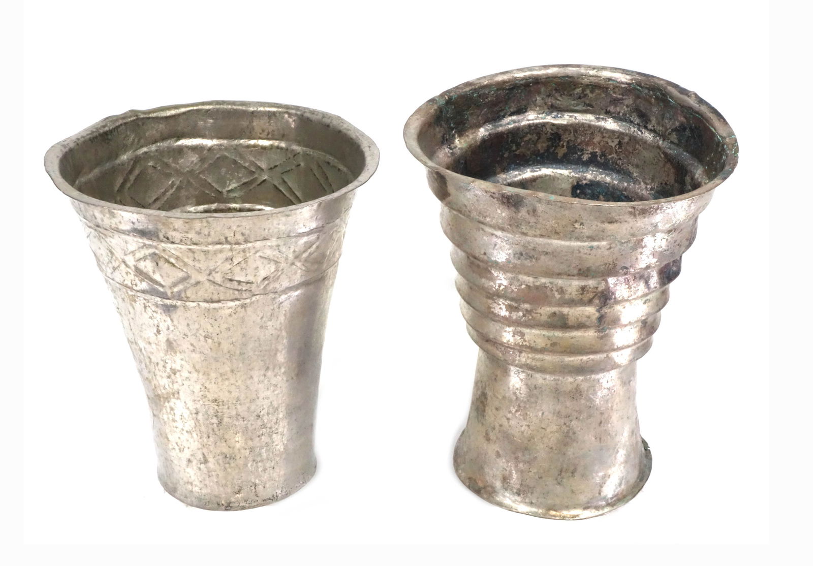 Pair Chimu Silver Keros: Pair Chimu Silver Keros. Late Int Period, Ca 1100-1400 AD, Deep cylindrical conical forms with wide rims; one with stepped bands; the other with row of chevron banded designs. Heighst: 5-1/2 and 6 inc