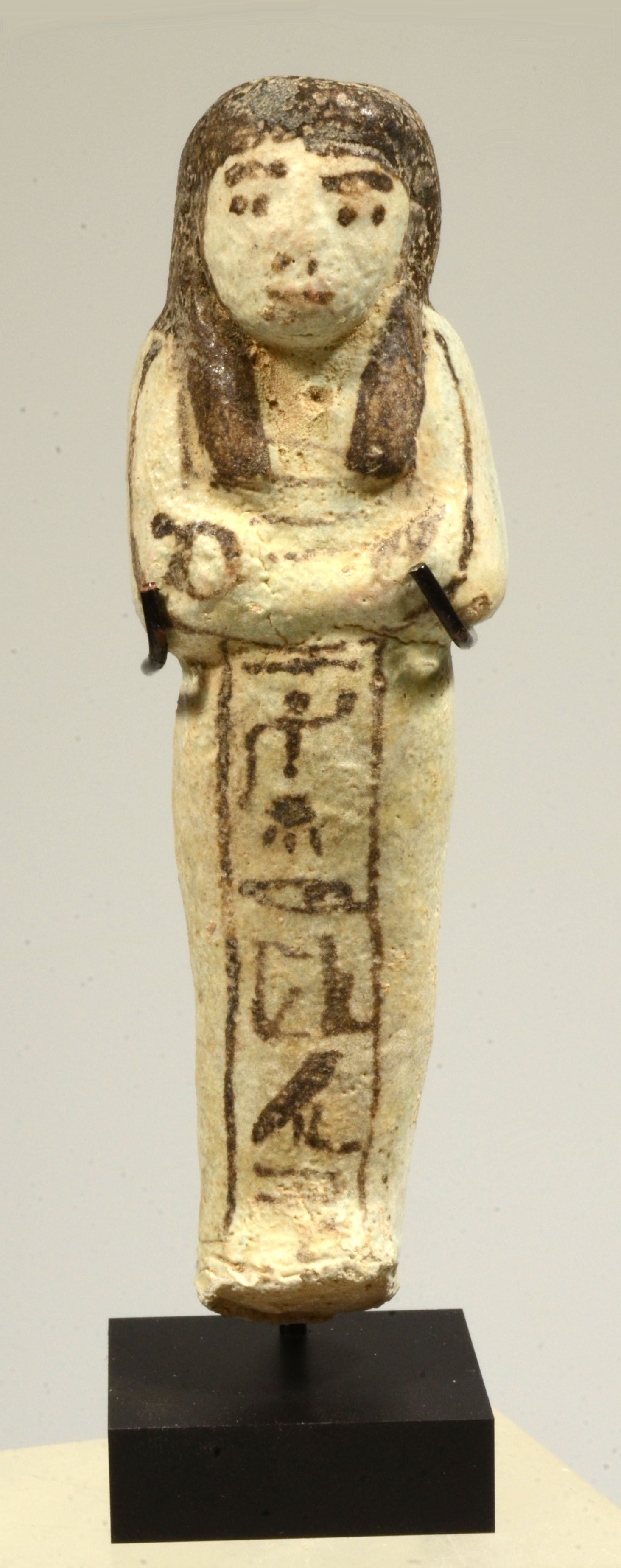 Egyptian Pale Green Glaze Faience Ushabti Inscribed for Horem: Period: Circa 19th Dynasty, 1550 - 1070 B.C.A pale blue-green faience mummiform ushabti having black details including painted wigs, facial details, arms holding the crook and scepter, (symbols of aut