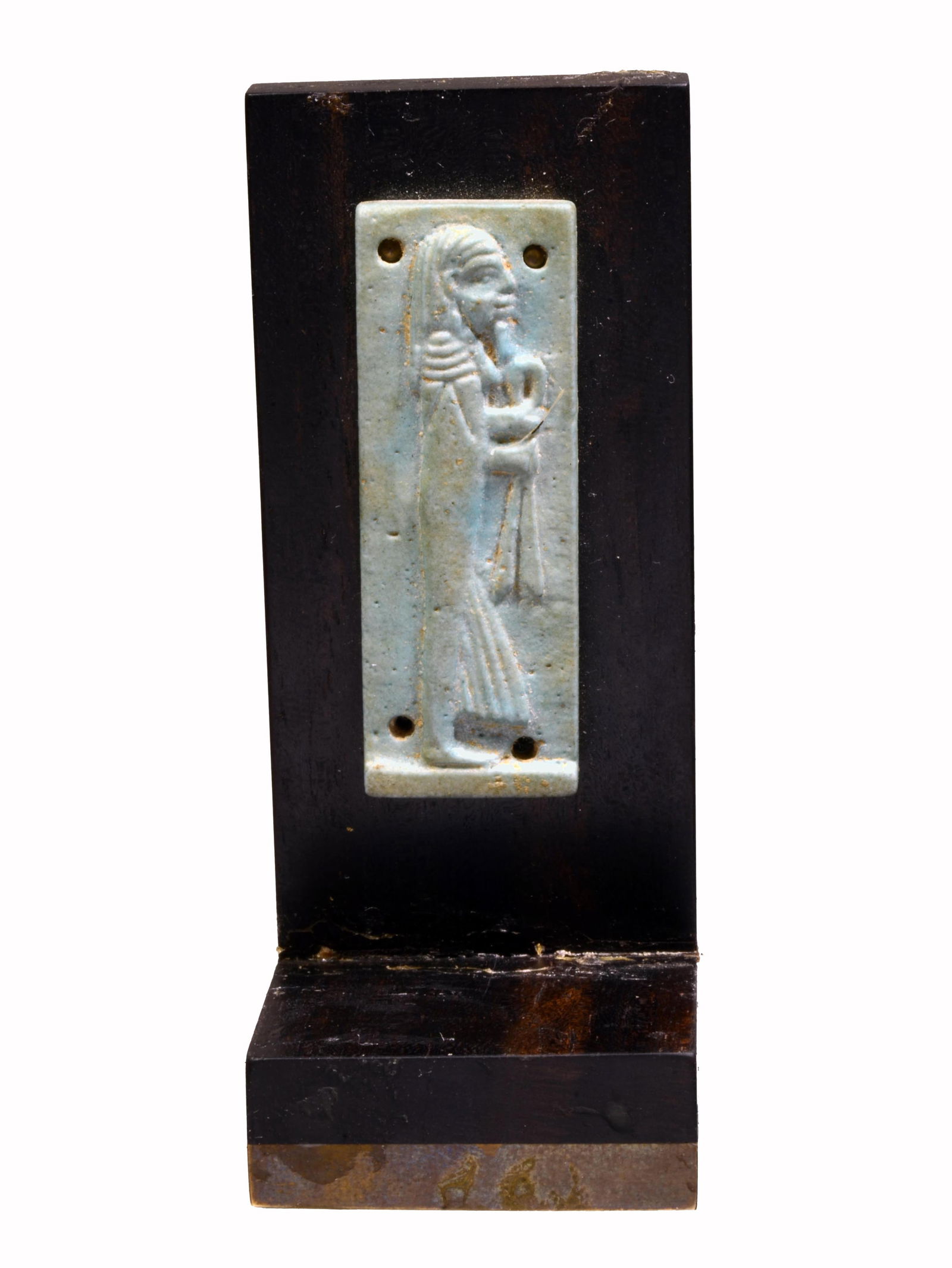 Egyptian Blue Faience Son of Horus Plaque: Late Period, Ca. 715 to 500 BC. A blue faience glaze depiction of a standing human headed Son of Horus; mummiform depicted in profile bearded and holding a scepter. Four loop holes for suspension. A p
