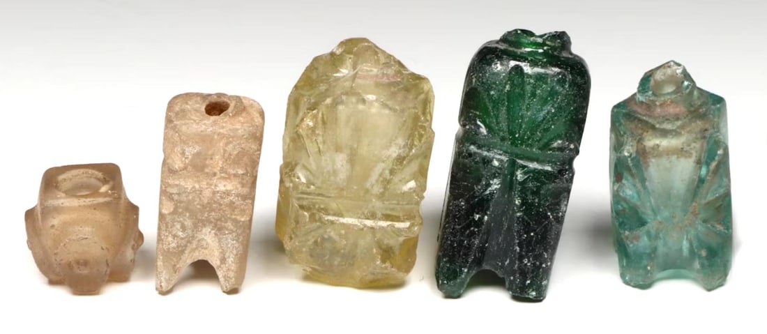 Islamic Colored Glass Molar Flasks or Unguentaria (5): Islamic era, 9th.-10th. Century A.D.From: Near East, possibly Persia, or possibly from Fustat, EgyptAll four bottles cast as solid blocks of glass, drilled out, then cut with a grinding wheel and poli