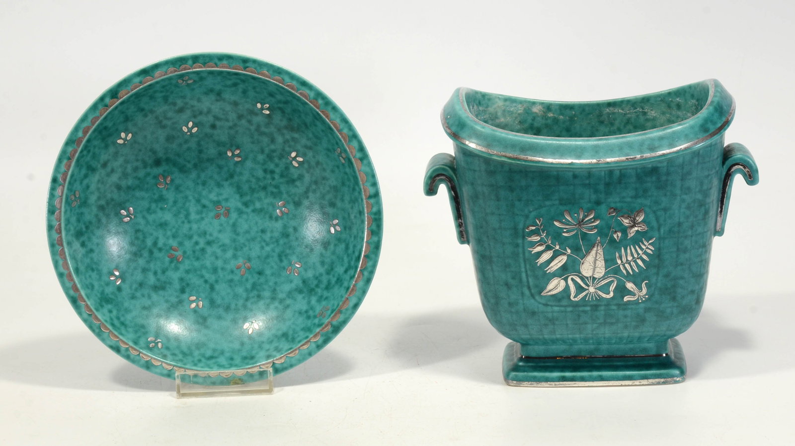 Wilhelm Kåge Gustavsberg Argenta Bowl and Jardinière Group, 1931–Mid-20th Century: Two pieces from Wilhelm Kåge’s iconic Argenta line for Gustavsberg, Sweden, celebrated for its turquoise glaze with sterling silver inlay.Round Bowl, Shape 1094Diameter: 7 in. (17.8 cm)Marked Gusta