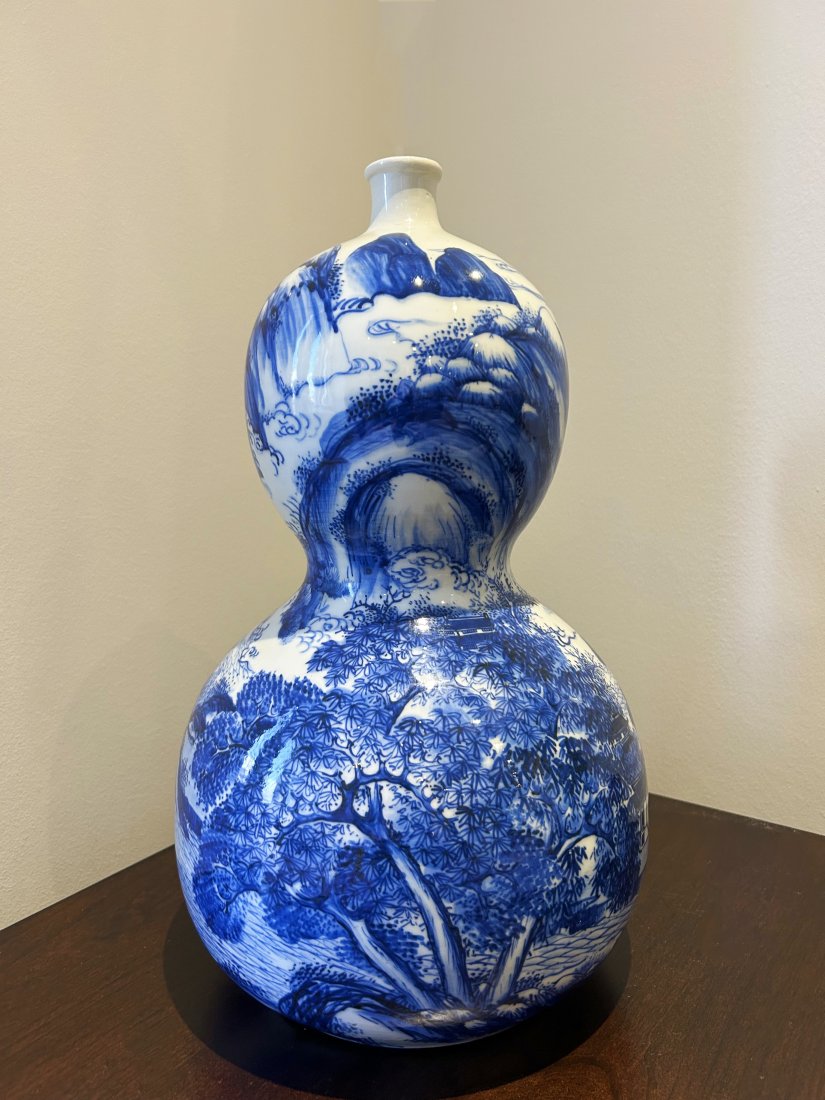 A Japanese Antique Blue&White Gourd Vase/日本青花葫蘆瓶: A Japanese blue and white double gourd vase, Meiji Period, 19th C. painted with a landscape, H: 43 CM . Neck with old sprayed restoration.日本明治時期青഑
