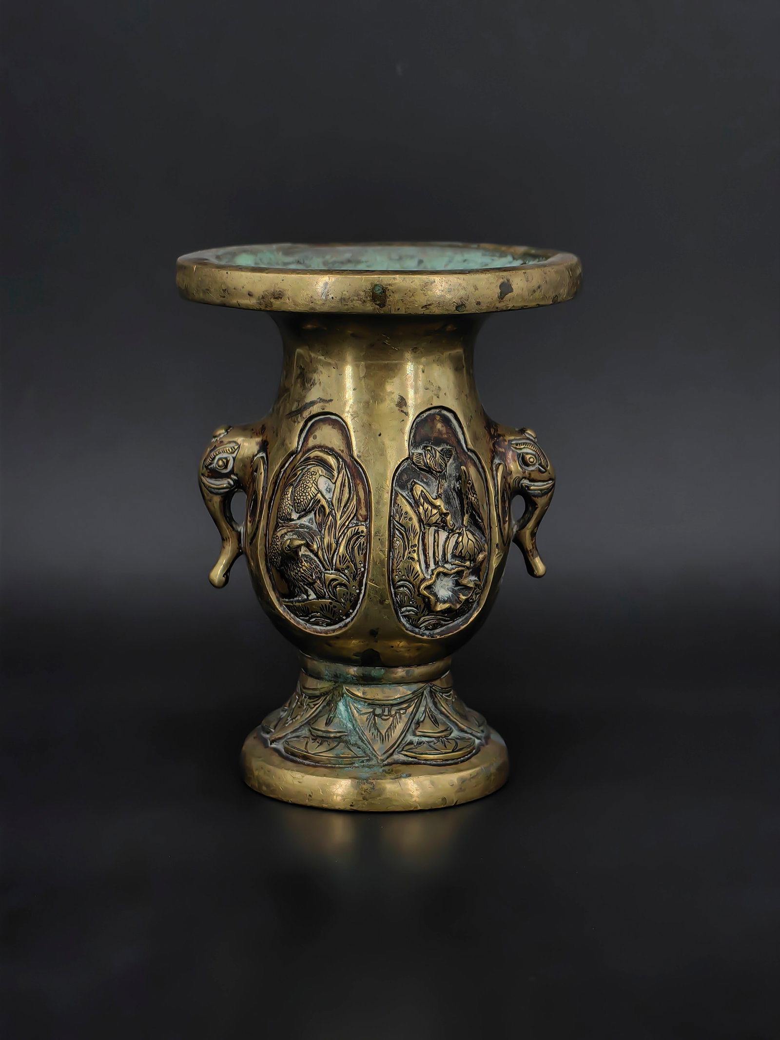 An Ancient Chinese Ritual Vessel: A finely cast bronze vase of archaic inspiration,18th, featuring a flared rim and pedestal base. The body is decorated with raised panels depicting birds, floral motifs, and traditional scenes,
