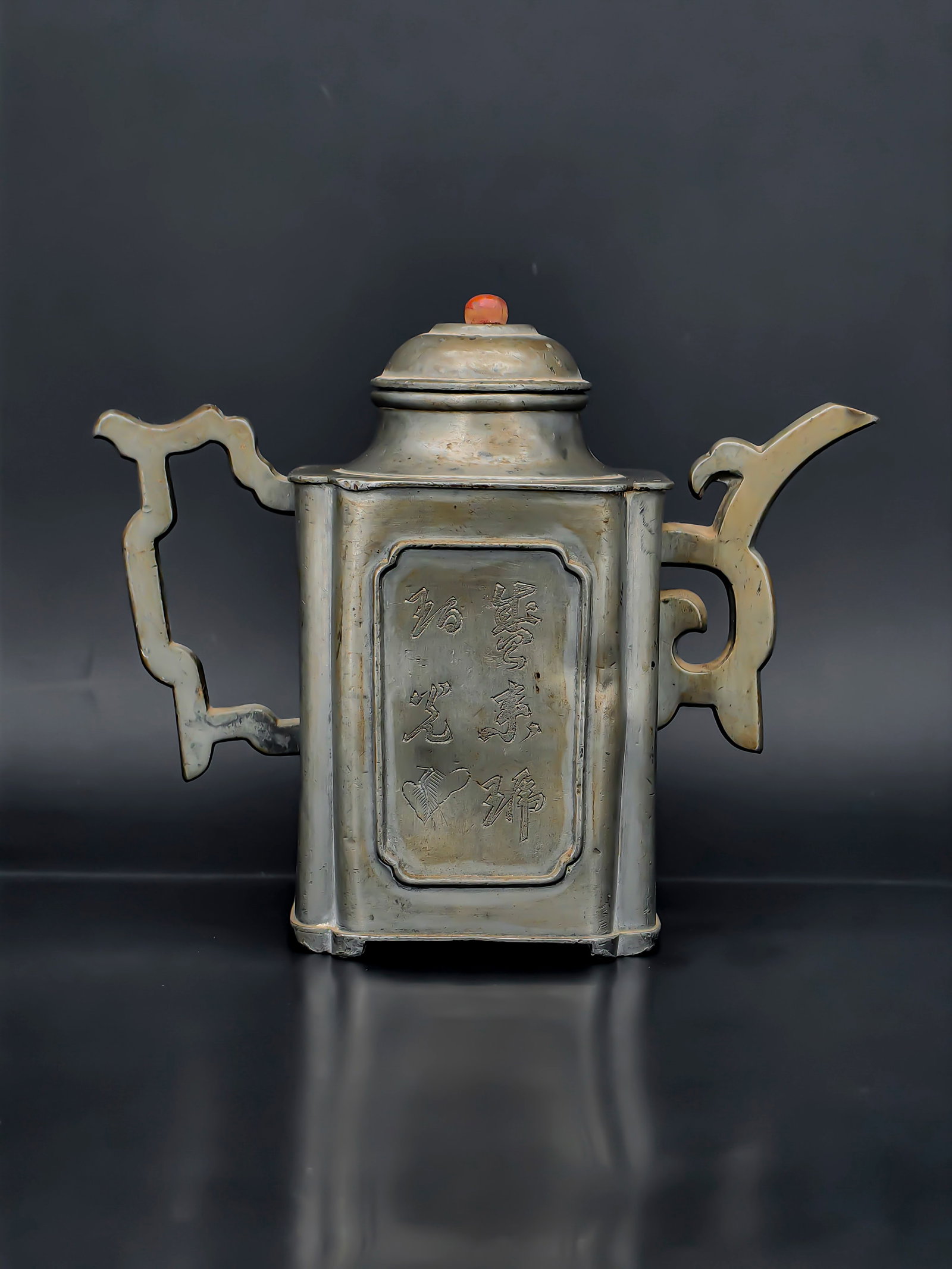 An Antique White Copper Teapot: A distinctive rectangular white copper (nickel silver) teapot of archaistic form, featuring a square body with rounded shoulders and a domed lid topped by a red bead finial. The front panel is finely