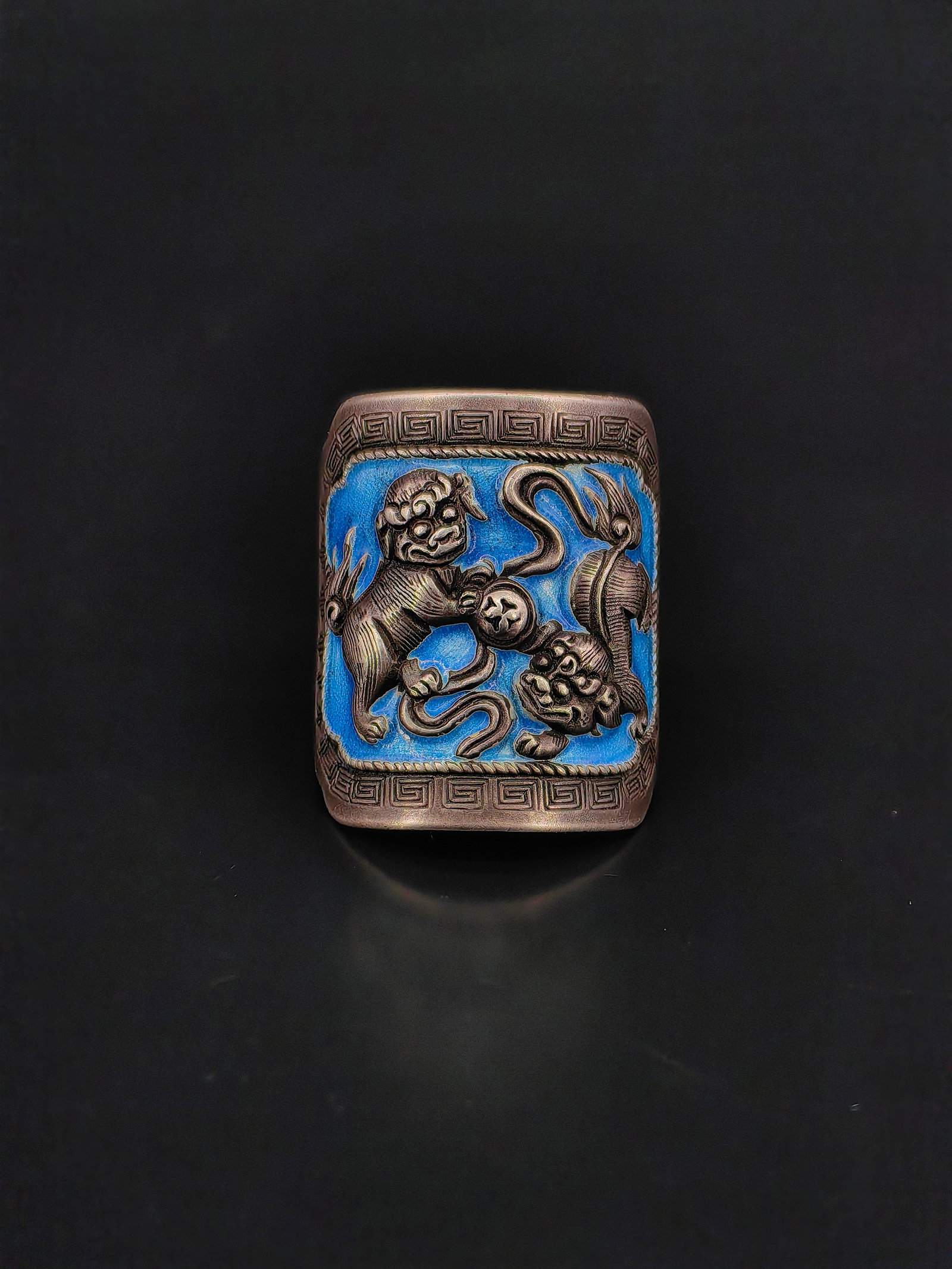 An Antique Chinese Ring: Antique Chinese silver ring decorated with a finely cast relief of mythical foo lions (guardian lions) playing with a sacred ball and ribbon, symbols of protection and prosperity in traditional Chines