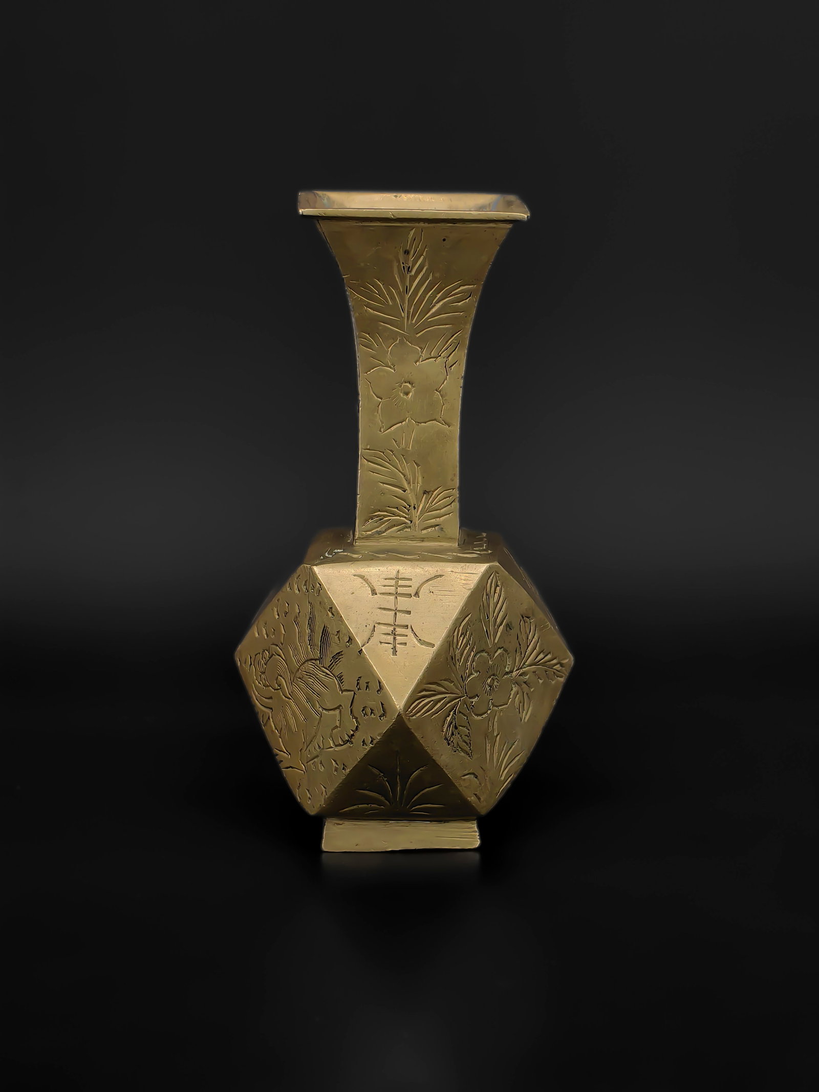An Antique Chinese Brass Vase: This exquisite Chinese Brass Square-Neck Vase features a unique faceted body adorned with intricate engravings of guardian lions, floral motifs, the "Shou" (longevity) character, and auspicious