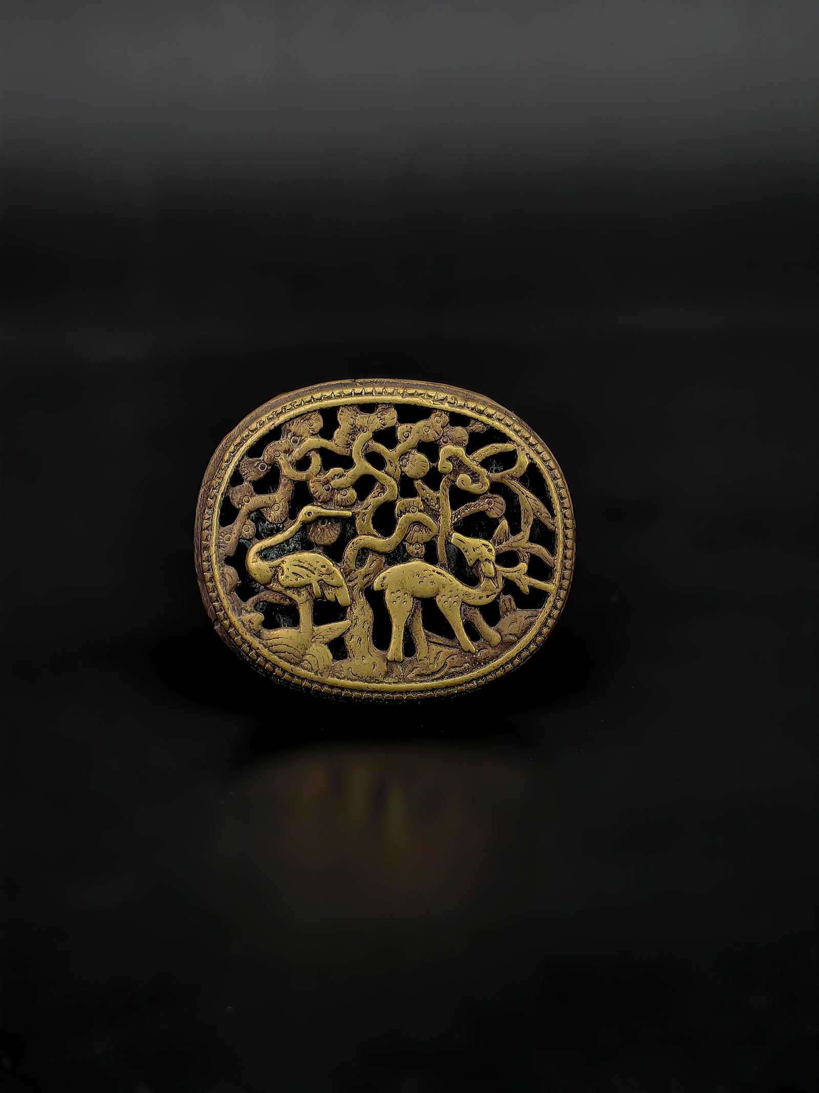 An Antique Chinese Bronze Buckle: This exquisite lot features sophisticated openwork craftsmanship. The front is decorated with the traditional Chinese "Lu He Tong Chun" (Deer and Crane) motif, symbolizing longevity and prosperity. Th