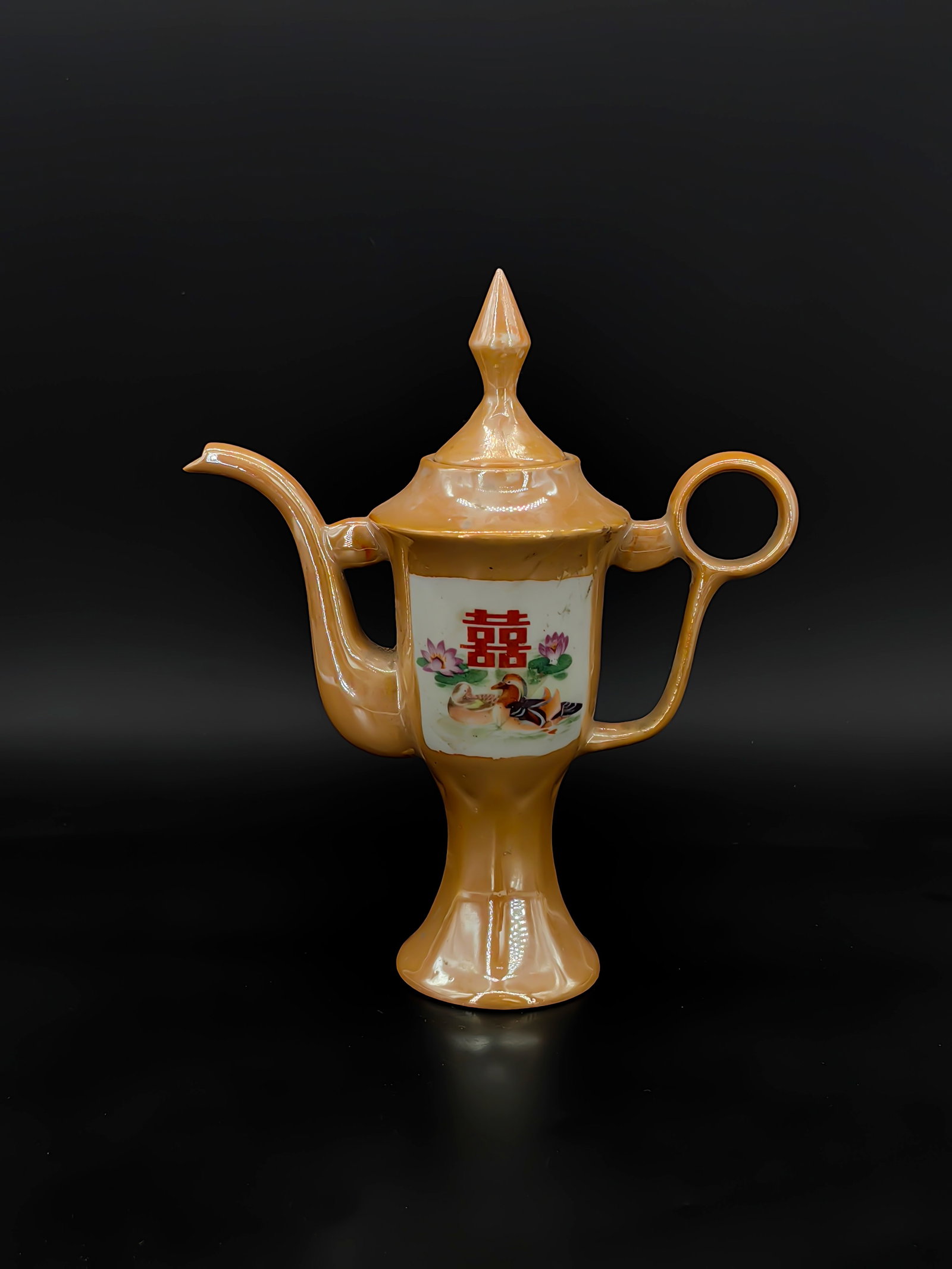 A 20th Century Pearlescent Orange-Glazed Ewer: Standing approximately 27cm tall, this distinctive ceramic ewer is a vibrant example of 20th-century folk-style porcelain. It features a striking pearlescent orange-yellow glaze that emits a metallic
